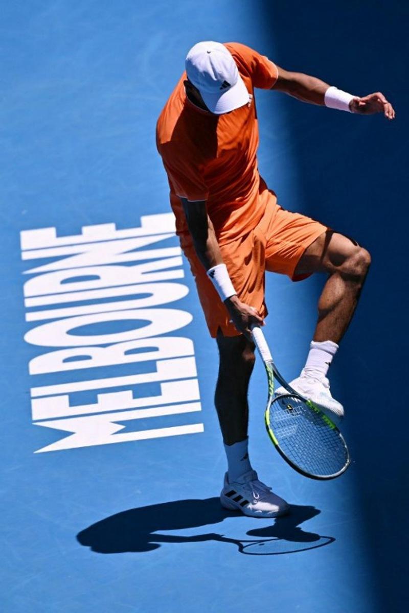 Canada's Felix Auger-Aliassime hits his foot with his racquet while playing against Portugal's Nuno Borges during their men's singles match on day two of the Australian Open tennis tournament in Melbourne on January 19, 2026.  WILLIAM WEST / AFP