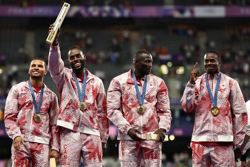 Gold medallists Canada's Andre De Grasse, Brendon Rodney, Jerome Blake and Aaron Brown celebrate on the podium after competing in the men's 4x100m relay final of the athletics event during the Paris 2024 Olympic Games at Stade de France in Saint-Denis, north of Paris, on August 9, 2024.  Anne-Christine POUJOULAT / AFP