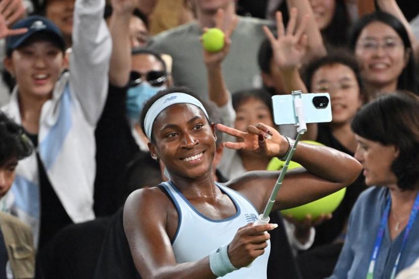 USA's Coco Gauff takes a selfie with fans after winning against Italy's Jasmine Paolini in their women's singles semi-final match at the Wuhan Open tennis tournament in Wuhan, Central China's Hubei province on October 11, 2025.  ADEK BERRY / AFP