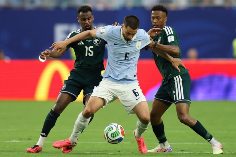 Saudi Arabia's midfielders #15 Abdullah Al-Khaibari, #06 Nasser Al-Dawsari (R) and Uruguay's midfielder #06 Rodrigo Bentancur fight for the ball during the 2026 World Cup Group H football match between Saudi Arabia and Uruguay at the Miami Stadium in Miami Gardens on June 15, 2026.   PATRICIA DE MELO MOREIRA / AFP
