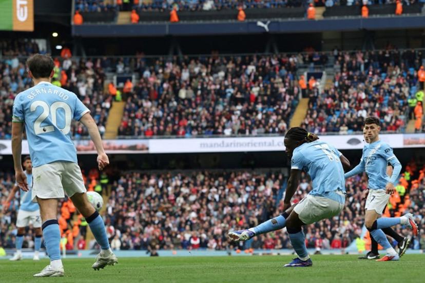 Manchester City's Belgian midfielder #11 Jeremy Doku (2R) shoots to score the opening goal during the English Premier League football match between Manchester City and Brentford at the Etihad Stadium in Manchester, north west England, on May 9, 2026.  Darren Staples / AFP