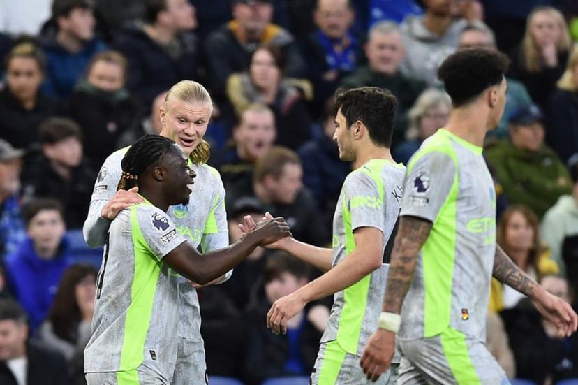 Manchester City's Belgian midfielder #11 Jeremy Doku (L) celebrates with teammates after scoring the opening goal during the English Premier League football match between Everton and Manchester City at Hill Dickinson Stadium in Liverpool on May 4, 2026.  PETER POWELL / AFP