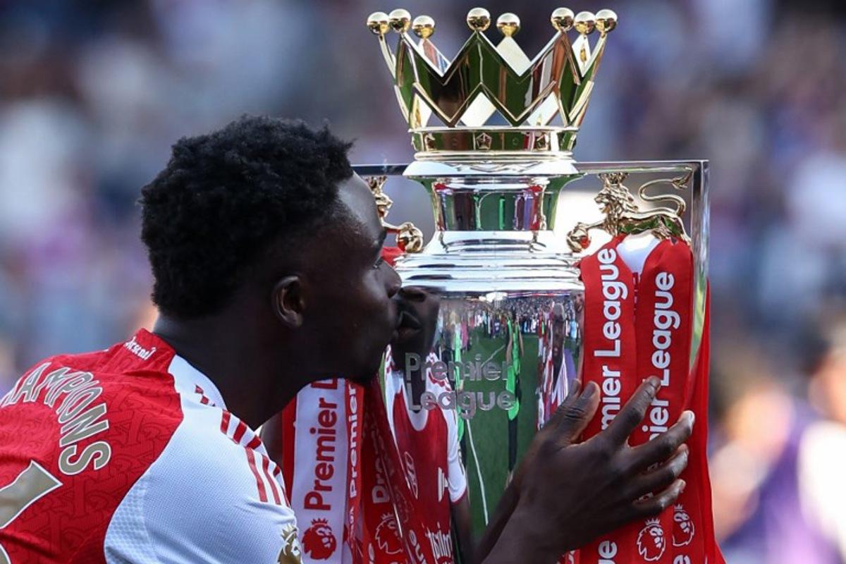 Arsenal's English midfielder #07 Bukayo Saka kisses the Premier League trophy at the presentation after the English Premier League football match between Crystal Palace and Arsenal at Selhurst Park in south London on May 24, 2026. Arsenal are English league champions for the first time since 2004, winning the league by seven points. Adrian Dennis / AFP