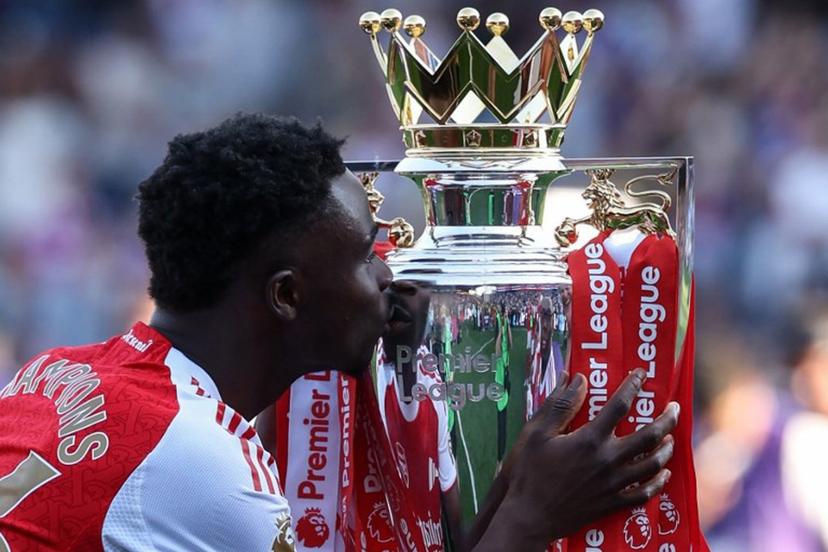Arsenal's English midfielder #07 Bukayo Saka kisses the Premier League trophy at the presentation after the English Premier League football match between Crystal Palace and Arsenal at Selhurst Park in south London on May 24, 2026. Arsenal are English league champions for the first time since 2004, winning the league by seven points. Adrian Dennis / AFP