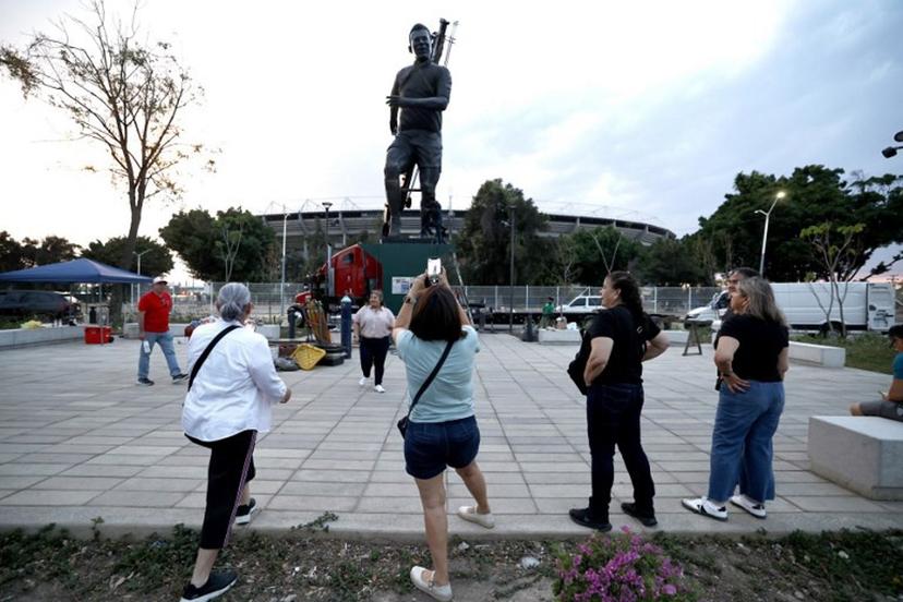 People take pictures as workers place a sculpture of late Brazilian football legend Pele, by artist Alejandro Velazco, called "La Canarinha" on the esplanade of the Jalisco Stadium in Guadalajara, Jalisco, Mexico, on May 17, 2026. The three-ton, 9-meter-high statue made of silver nitrate bronze was placed at Jalisco stadium as part of the events of the 2026 FIFA World Cup to be held in Mexico. ULISES RUIZ / AFP