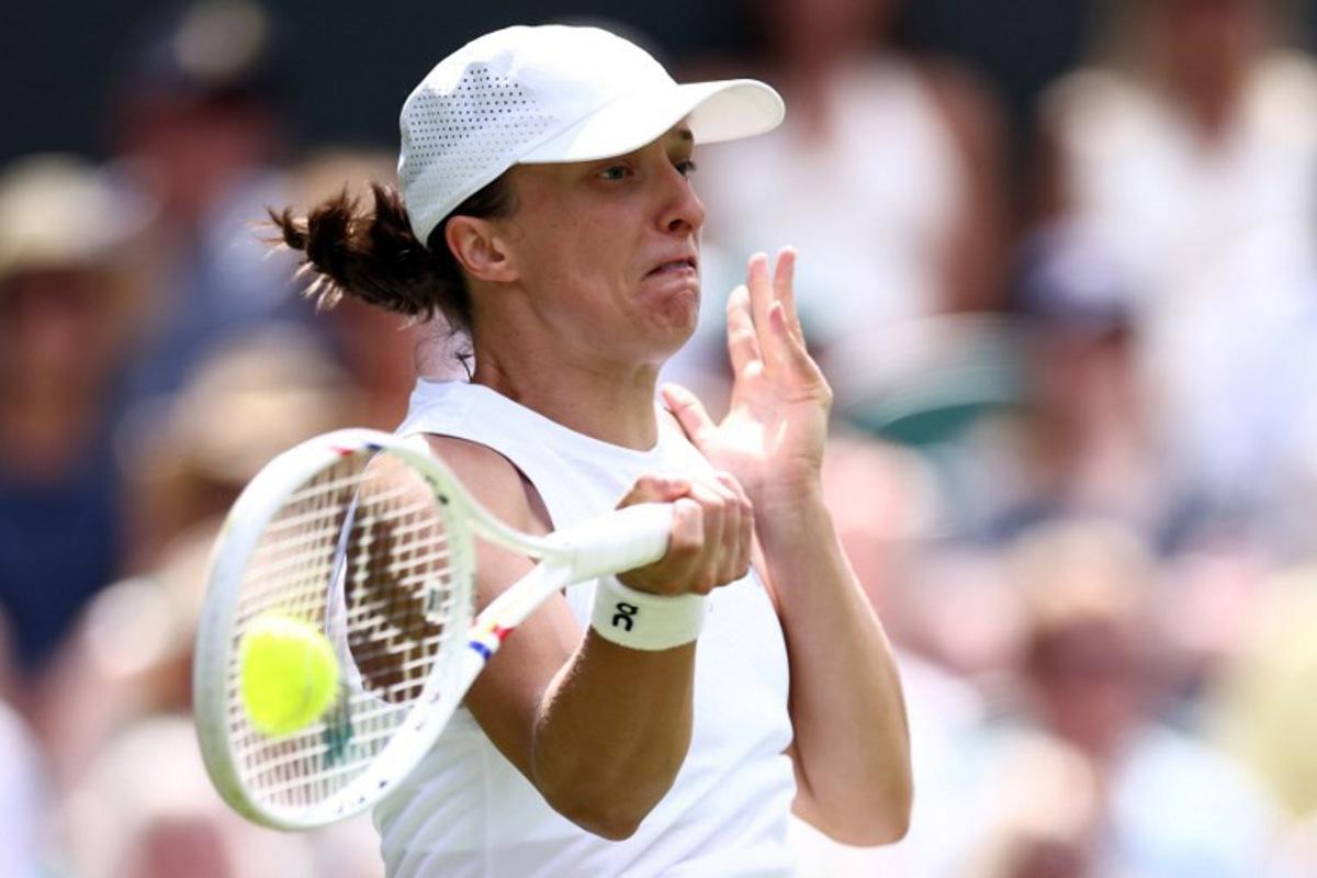 Poland's Iga Swiatek returns the ball to US player Taylor Townsend during their women's singles first round tennis match on the second day of the 2026 Wimbledon Championships at The All England Lawn Tennis and Croquet Club in Wimbledon, southwest London, on June 30, 2026.  Henry Nicholls / AFP