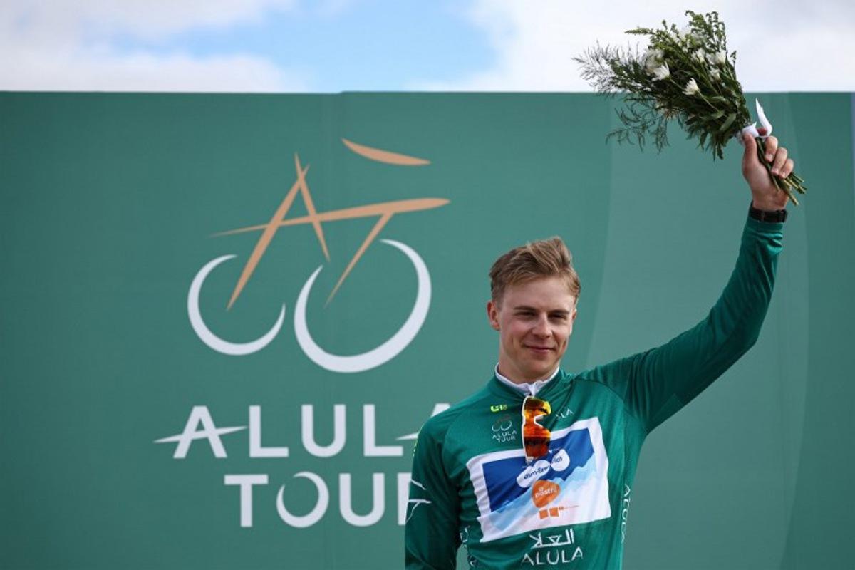 Dutch Casper van Uden (DSM-Firmenich PostNL), first at the general classification, holds flowers on the podium after the third stage between Al-Ula International Airport and Al-Ula Camel Cup Track, during the Al-Ula Tour cycling race at Al-Ula Camel Cup Track on February 1, 2024.  Anne-Christine POUJOULAT / AFP