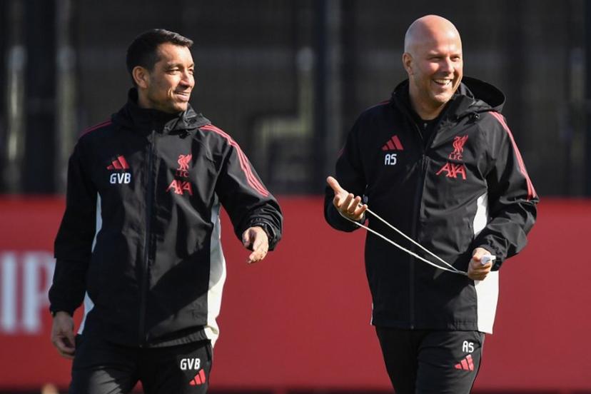 Liverpool's Dutch manager Arne Slot (R) Liverpool's Dutch Assistant Manager and Giovanni van Bronckhorst smile during a team training session at their training ground in Kirkby, Liverpool, north-west England on March 17, 2026, on the eve of their UEFA Champions League, last 16 second leg football match against Galatasaray.  PETER POWELL / AFP