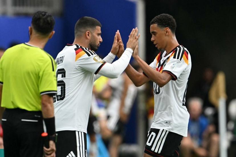 Germany's midfielder #10 Jamal Musiala (R) taps hands with Germany's forward #26 Deniz Undav (L) as he is substituted  during the 2026 World Cup Group E football match between Germany and Curacao at the Houston Stadium in Houston on June 14, 2026.   RONALDO SCHEMIDT / AFP
