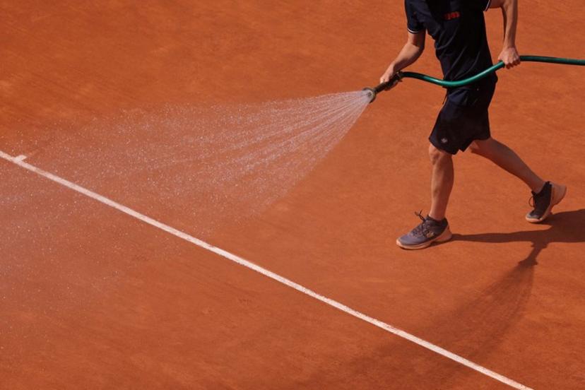 An employee sprays water on the clay during their men's singles quarter final match between Serbia's Novak Djokovic and Russia's Karen Khachanov on day ten of the Roland-Garros Open tennis tournament at the Court Philippe-Chatrier in Paris on June 6, 2023.  Thomas SAMSON / AFP