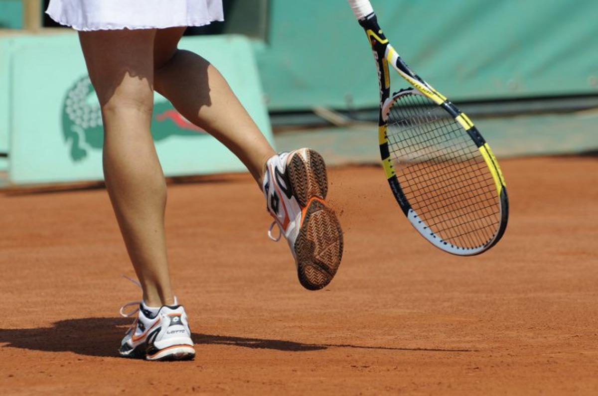 Italy's Francesca Schiavone knocks clay from the tread of her shoes as she prepares to serve against Australia's Samantha Stosur during their women's final match in the French Open tennis championship at the Roland Garros stadium, on June 5, 2010, in Paris. AFP PHOTO/BORIS HORVAT  BORIS HORVAT / AFP