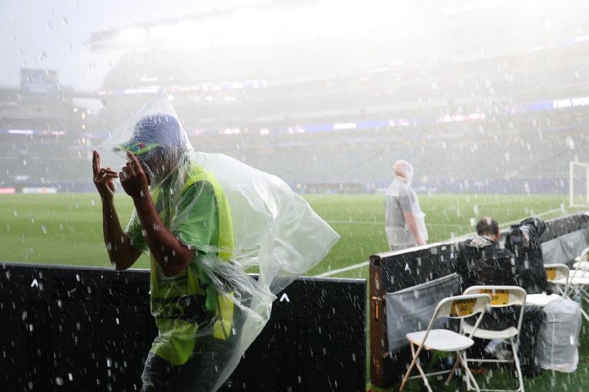 A photographer wears a raincoat as the 2026 World Cup Group I football match between France and Iraq is suspended due to adverse weather at the Philadelphia Stadium in Philadelphia on June 22, 2026.   FRANCK FIFE / AFP
