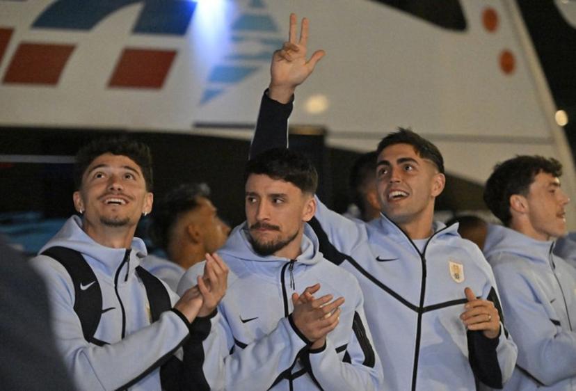 (L to R) Uruguay's midfielder #15 Emiliano Martinez, Uruguay's defender #22 Joaquin Piquerez and Uruguay's goalkeeper #12 Santiago Mele acknowledge fans as the Uruguay national football team arrives at Carrasco International Airport ahead of its departure to Mexico for the FIFA 2026 World Cup football tournament, in Ciudad de la Costa, Canelones department, Uruguay, on June 9, 2026.  Santiago Mazzarovich / AFP