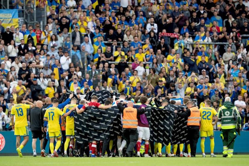Denmark's and Ukraine's players huddle to accompany Denmark's midfielder #10 Christian Eriksen to a waiting ambulance during the football international friendly match between Denmark and Ukraine at Odense Stadium in Denmark, on June 7, 2026. Christian Eriksen collapsed during Denmark's friendly against Ukraine on June 7, 2026, five years after he suffered a cardiac arrest during the European Championships. Bo Amstrup / Ritzau Scanpix / AFP