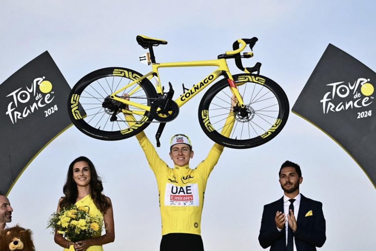 UAE Team Emirates team's Slovenian rider Tadej Pogacar celebrates his overall victory on the podium with the overall leader's yellow jersey after the 21st and final stage of the 111th edition of the Tour de France cycling race, a 33,7 km individual time-trial between Monaco and Nice, on July 21, 2024.  Marco BERTORELLO / AFP