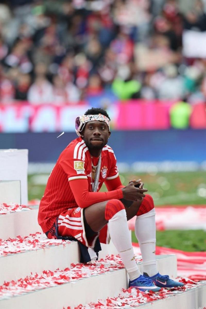 Bayern Munich's Canadian defender #19 Alphonso Davies sits on the stairs during celebrations for the Bundesliga trophy after wining the German first division Bundesliga football match between FC Bayern Munich and FC Cologne in Munich, southern Germany, on May 16, 2026.  Alexandra BEIER / AFP