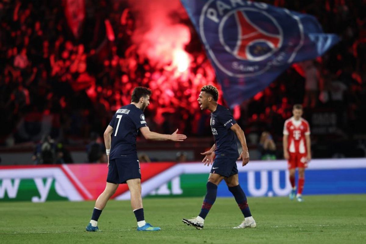 Paris Saint-Germain's Georgian forward #07 Khvicha Kvaratskhelia (L) celebrates with Paris Saint-Germain's French midfielder #14 Desire Doue after scoring his team first goal during the UEFA Champions League semi-final first leg football match between Paris Saint-Germain (PSG) and Bayern Munich at the Parc des Princes in Paris on April 28, 2026.  Anne-Christine POUJOULAT / AFP