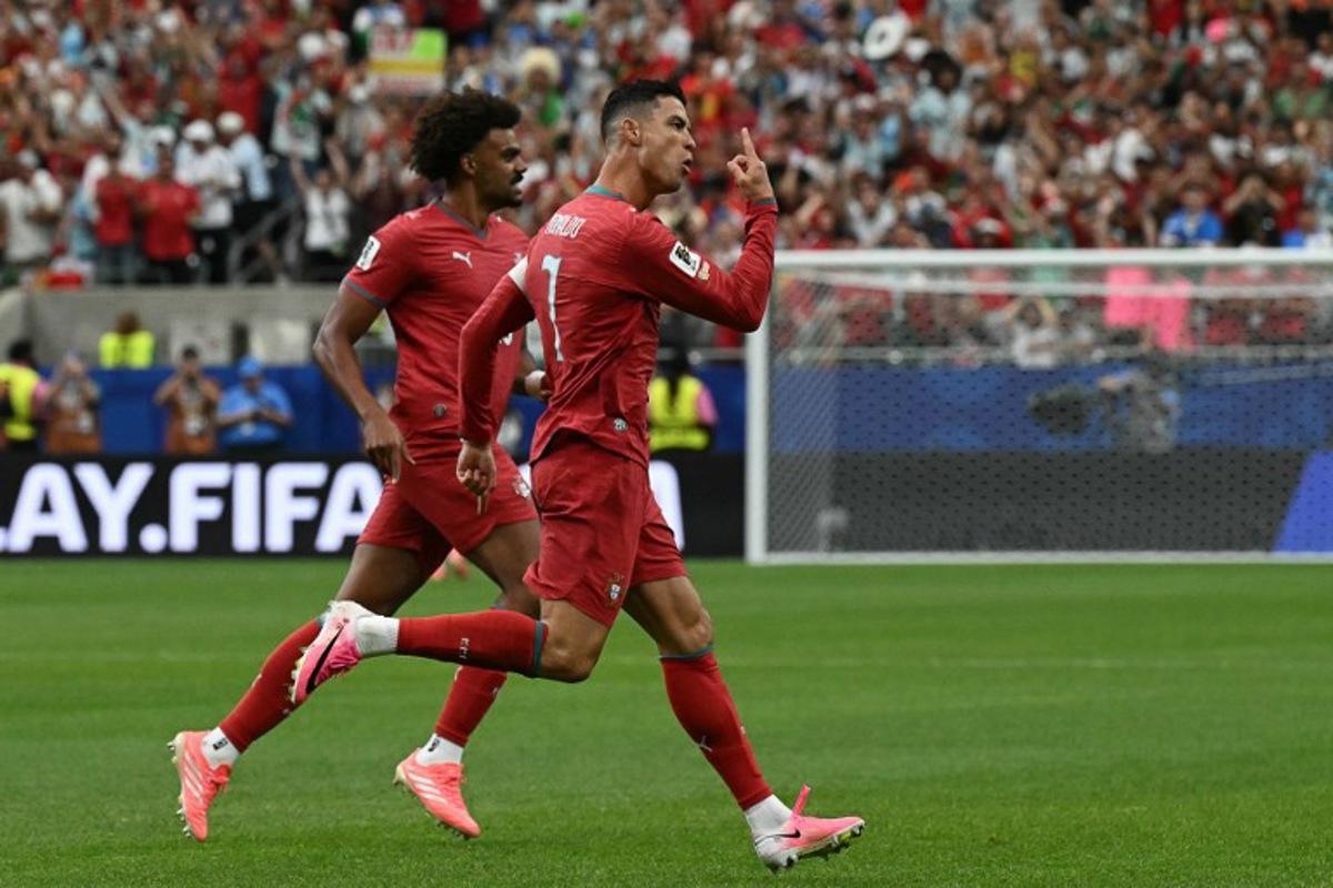 Portugal's forward #07 Cristiano Ronaldo (R) celebrates after scoring the opening goal during the 2026 World Cup Group K football match between Portugal and Uzbekistan at the Houston Stadium in Houston on June 23, 2026.   RONALDO SCHEMIDT / AFP