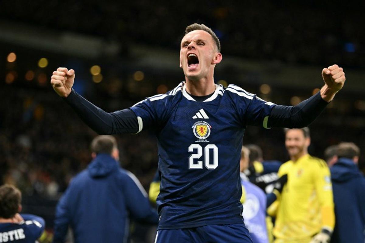 Scotland's striker #20 Lawrence Shankland celebrates on the pitch after the FIFA World Cup 2026 European qualification football match between Scotland and Denmark at Hampden Park in Glasgow on November 18, 2025.  Scotland scored two dramatic stoppage-time goals to beat 10-man Denmark 4-2 on Tuesday and reach the World Cup for the first time since 1998.  ANDY BUCHANAN / AFP