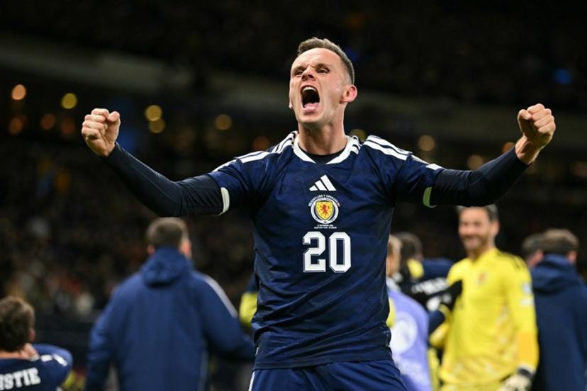 Scotland's striker #20 Lawrence Shankland celebrates on the pitch after the FIFA World Cup 2026 European qualification football match between Scotland and Denmark at Hampden Park in Glasgow on November 18, 2025.  Scotland scored two dramatic stoppage-time goals to beat 10-man Denmark 4-2 on Tuesday and reach the World Cup for the first time since 1998.  ANDY BUCHANAN / AFP