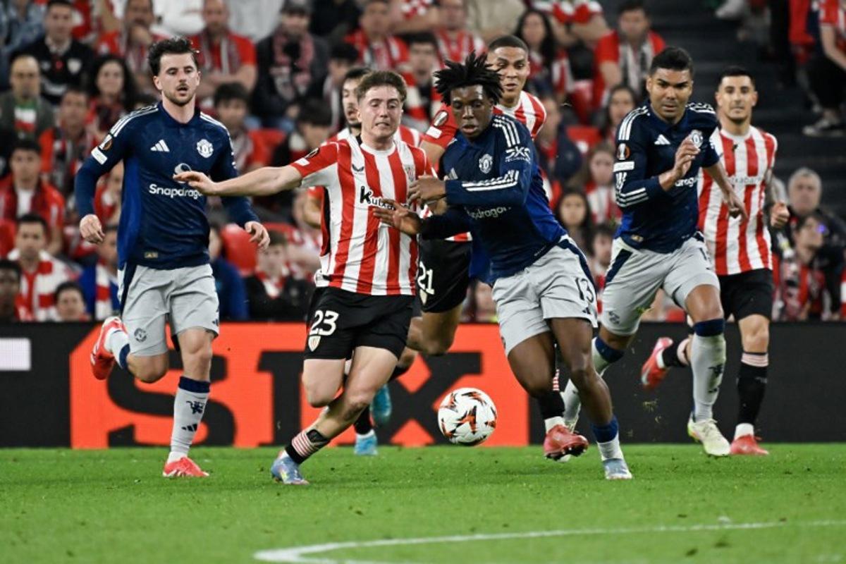 Athletic Bilbao's Spanish midfielder #23 Mikel Jauregizar Alboniga (L) challenges Manchester United's Danish defender #13 Patrick Dorgu for the ball during the UEFA Europa League semi final first leg football match between Athletic Club Bilbao and Manchester United at the San Mames stadium in Bilbao, on May 1, 2025. ANDER GILLENEA / AFP