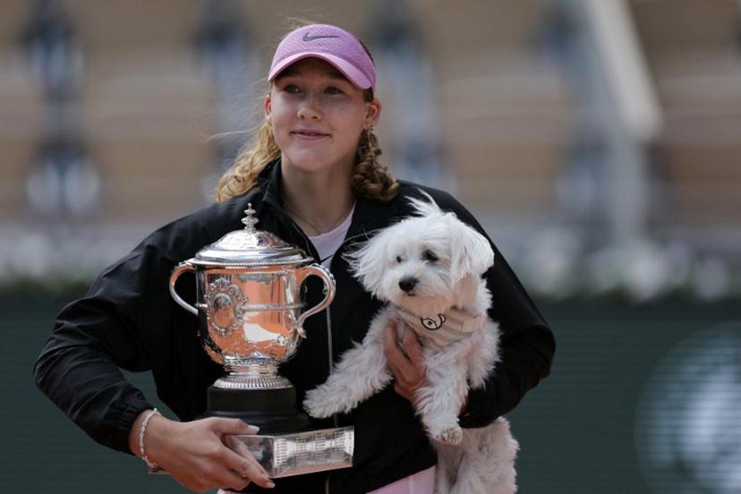 Russia's Mirra Andreeva poses with the Coupe Suzanne Lenglen (Suzanne Lenglen Trophy) and her dog after winning the French Open tennis tournament women's singles final match against Poland's Maja Chwalinska on day 14 of the French Open tennis tournament on Court Philippe-Chatrier at the Roland-Garros Complex in Paris on June 6, 2026.  Thomas SAMSON / AFP
