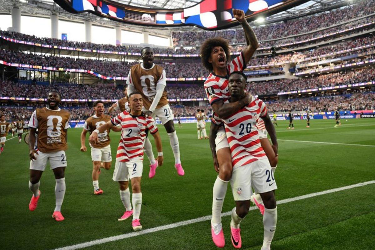 US forward #20 Folarin Balogun celebrates with teammates after scoring his team's third goal during the 2026 World Cup Group D football match between USA and Paraguay at the Los Angeles Stadium in Inglewood on June 12, 2026.  Patrick T. Fallon / AFP