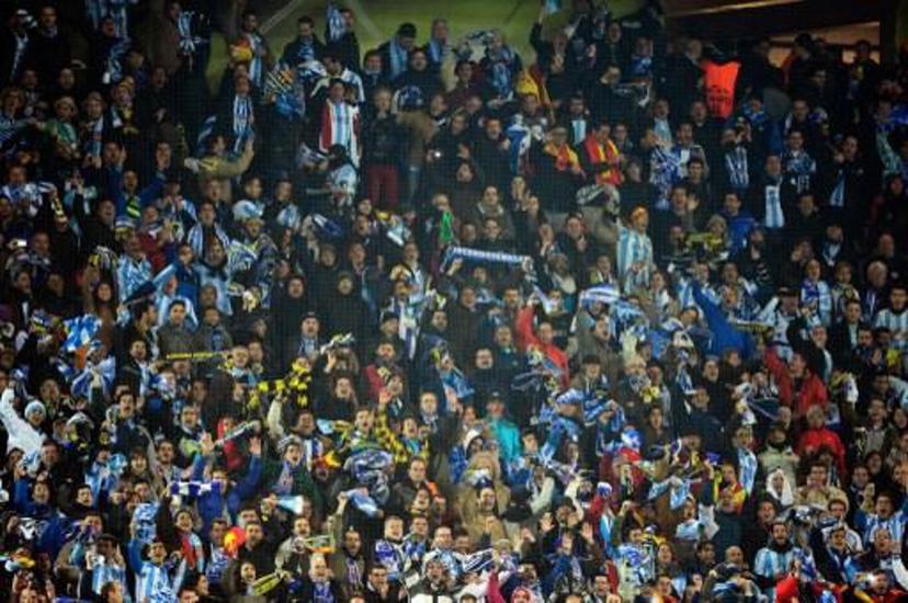 Malaga's fans cheer during the UEFA Champions League quarter-final second-leg football match Borussia Dortmund vs Malaga CF in Dortmund, western Germany on April 9, 2013. Dortmund won the match 3-2 to qualify for the semi-finals. AFP PHOTO / JOHN MACDOUGALL