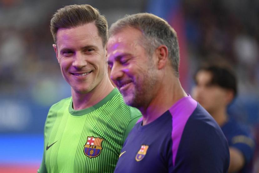 Barcelona's German coach Hans-Dieter Flick (R) and Barcelona's German goalkeeper Marc-Andre Ter Stegen speak before the 60th Joan Gamper Trophy football match between FC Barcelona and Como 1907 at Johan Cruyff Stadium in Barcelona on August 10, 2025.  Josep LAGO / AFP