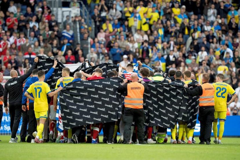 Denmark's and Ukraine's players huddle to accompany Denmark's midfielder #10 Christian Eriksen to a waiting ambulance during the football international friendly match between Denmark and Ukraine at Odense Stadium in Denmark, on June 7, 2026. Christian Eriksen collapsed during Denmark's friendly against Ukraine on June 7, 2026, five years after he suffered a cardiac arrest during the European Championships. Bo Amstrup / Ritzau Scanpix / AFP