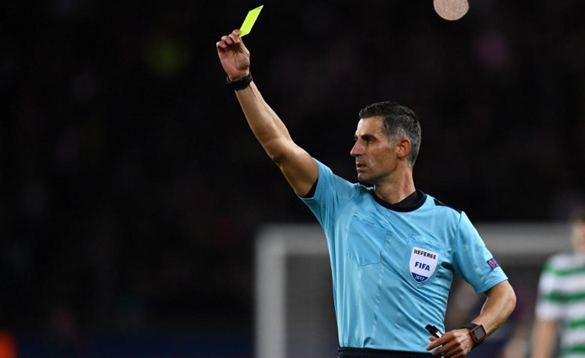 Greece's referee Tasos Sidiropoulos issues a yellow card during the UEFA Champions League Group B football match between Paris Saint-Germain (PSG) and Glasgow Celtic at Parc des Princes Stadium in Paris on November 22, 2017.   FRANCK FIFE / AFP