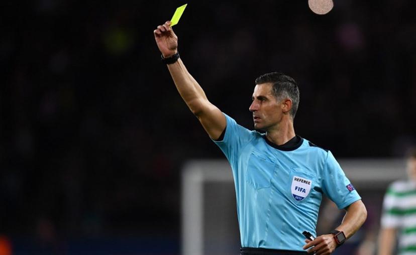 Greece's referee Tasos Sidiropoulos issues a yellow card during the UEFA Champions League Group B football match between Paris Saint-Germain (PSG) and Glasgow Celtic at Parc des Princes Stadium in Paris on November 22, 2017.   FRANCK FIFE / AFP