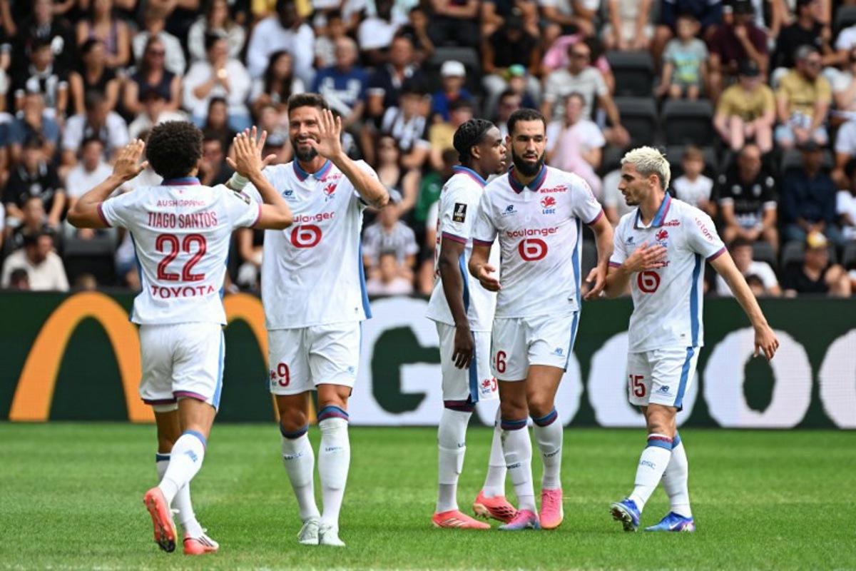 Lille's Portuguese defender #22 Tiago Santos (L) celebrates with teammates after scoring his team's first goal during the French L1 football match between Angers SCO and LOSC Lille at the Stade Raymond Kopa in Angers, western France on August 23, 2026.  Sebastien Salom-Gomis / AFP