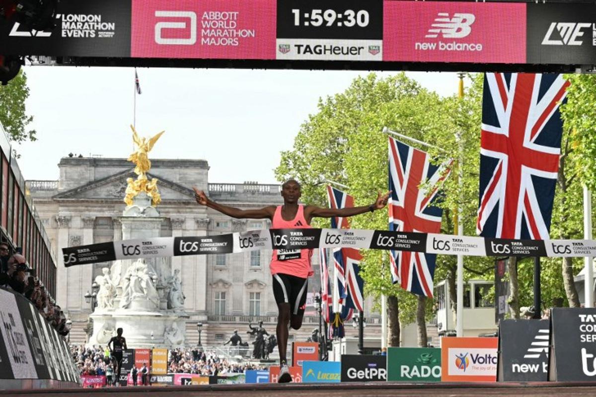 Kenya's Sabastian Sawe crosses the line to win the men's race in a new world record time at the 2026 London Marathon in central London on April 26, 2026. Kenya's Sabastian Sawe broke the two-hour mark for the first time in history on Sunday in winning the London Marathon. JUSTIN TALLIS / AFP