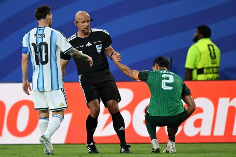 Polish referee Szymon Marciniak lifts Algeria's defender #02 Aissa Mandi as he reacts in pain next to Argentina's forward #10 Lionel Messi during the 2026 World Cup Group J football match between Argentina and Algeria at the Kansas City Stadium in Kansas City on June 16, 2026.   ROBERTO SCHMIDT / AFP