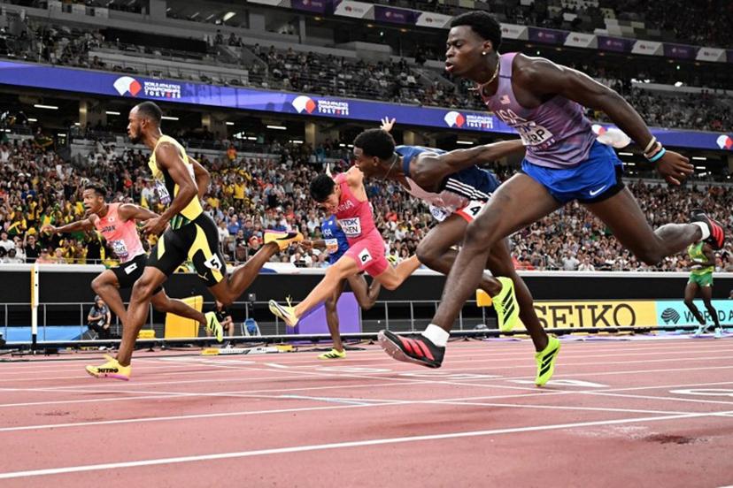 Athletes including US' athlete Ja'Kobe Tharp (R) and Jamaica's athlete Orlando Bennett (2nd L) cross the finish line in the men's 110m hurdles heats during the World Athletics Championships in Tokyo on September 15, 2025.  Jewel SAMAD / AFP