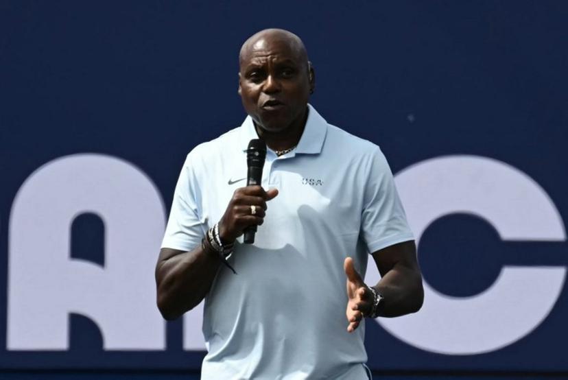US former athlete Carl Lewis addresses guests on stage at the Champions Park at Trocadero during the Paris 2024 Olympic Games in Paris on August 9, 2024, with the Eiffel Tower visible in the background.  CARL DE SOUZA / AFP