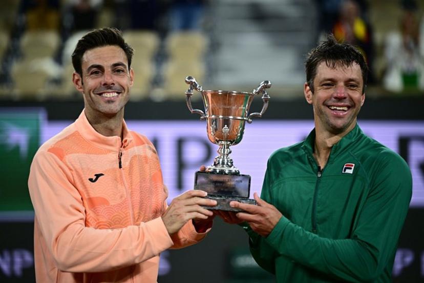 Spain's Marcel Granollers (L) and Argentina's Horacio Zeballos hold their trophy after winning their men's doubles final match against Britain's Joe Salisbury and Britain's Neal Skupski on day 14 of the French Open tennis tournament on Court Philippe-Chatrier at the Roland-Garros Complex in Paris on June 7, 2025.  JULIEN DE ROSA / AFP