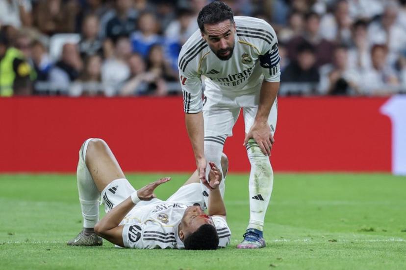 Real Madrid's French forward #10 Kylian Mbappe (L) lies on the pitch with blood on his face after colliding with Girona's Brazilian defender #12 Vitor Reis (not pictured) as Real Madrid's Spanish defender #02 Dani Carvajal assists during the Spanish league football match between Real Madrid CF and Girona FC at the Santiago Bernabeu stadium in Madrid on April 10, 2026.  Thomas COEX / AFP