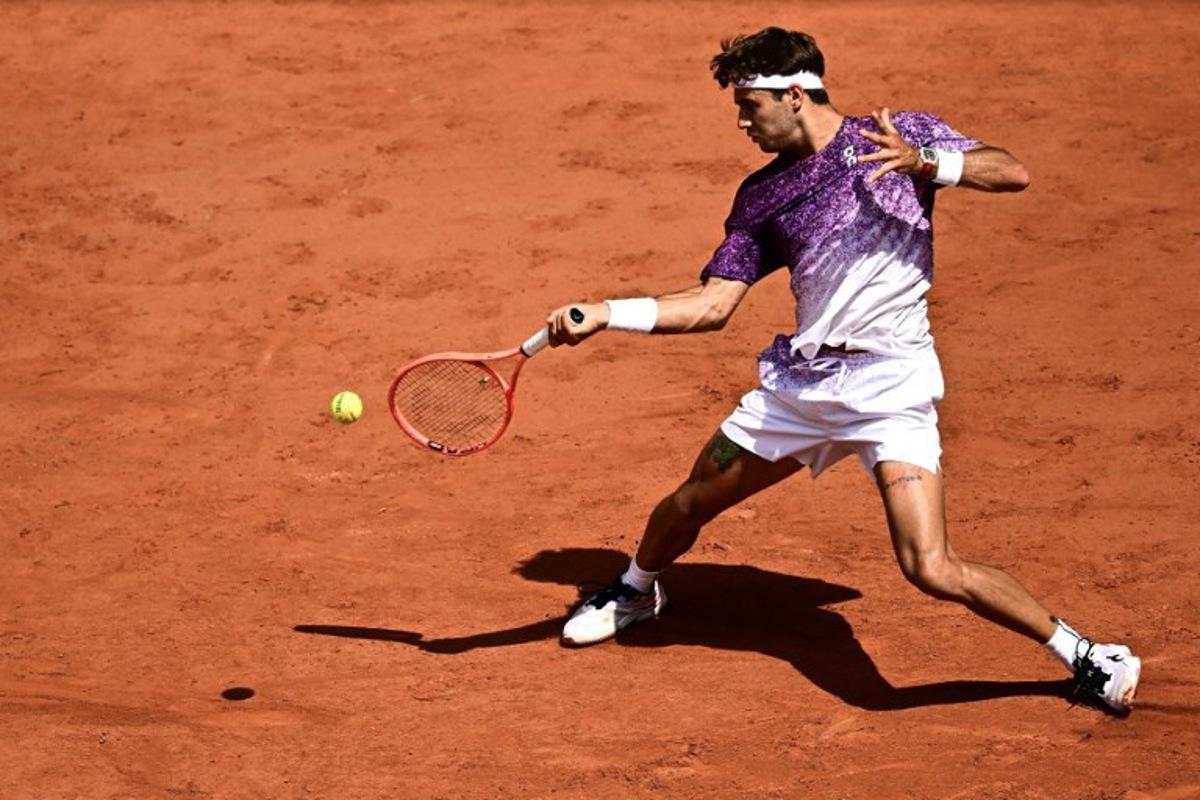Italy's Flavio Cobolli plays a forehand return to US Learner Tien during their men's singles match on day 7 of the French Open tennis tournament on Court Philippe-Chatrier at the Roland-Garros Complex in Paris on May 30, 2026.  JULIEN DE ROSA / AFP