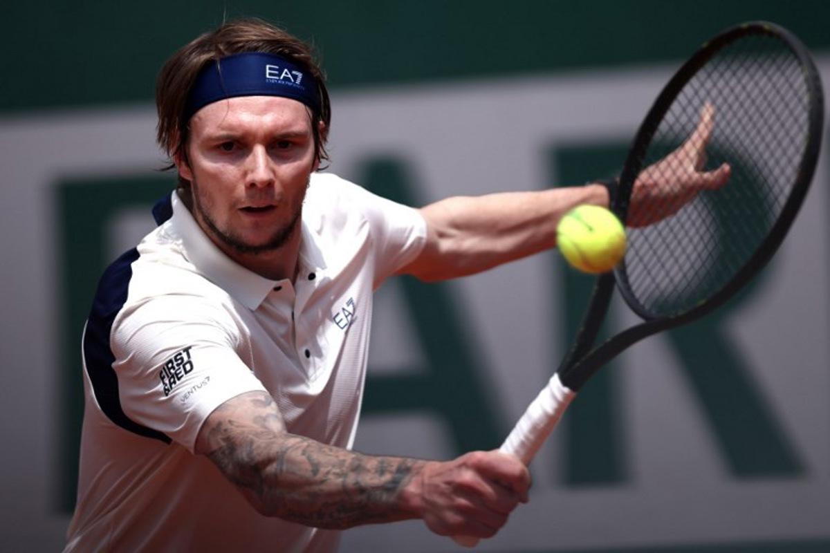 Kazakhstan's Alexander Bublik plays a backhand return to Australia's Alex De Minaur during their men's singles match on day 5 of the French Open tennis tournament at the Roland-Garros Complex in Paris on May 29, 2025.  Anne-Christine POUJOULAT / AFP