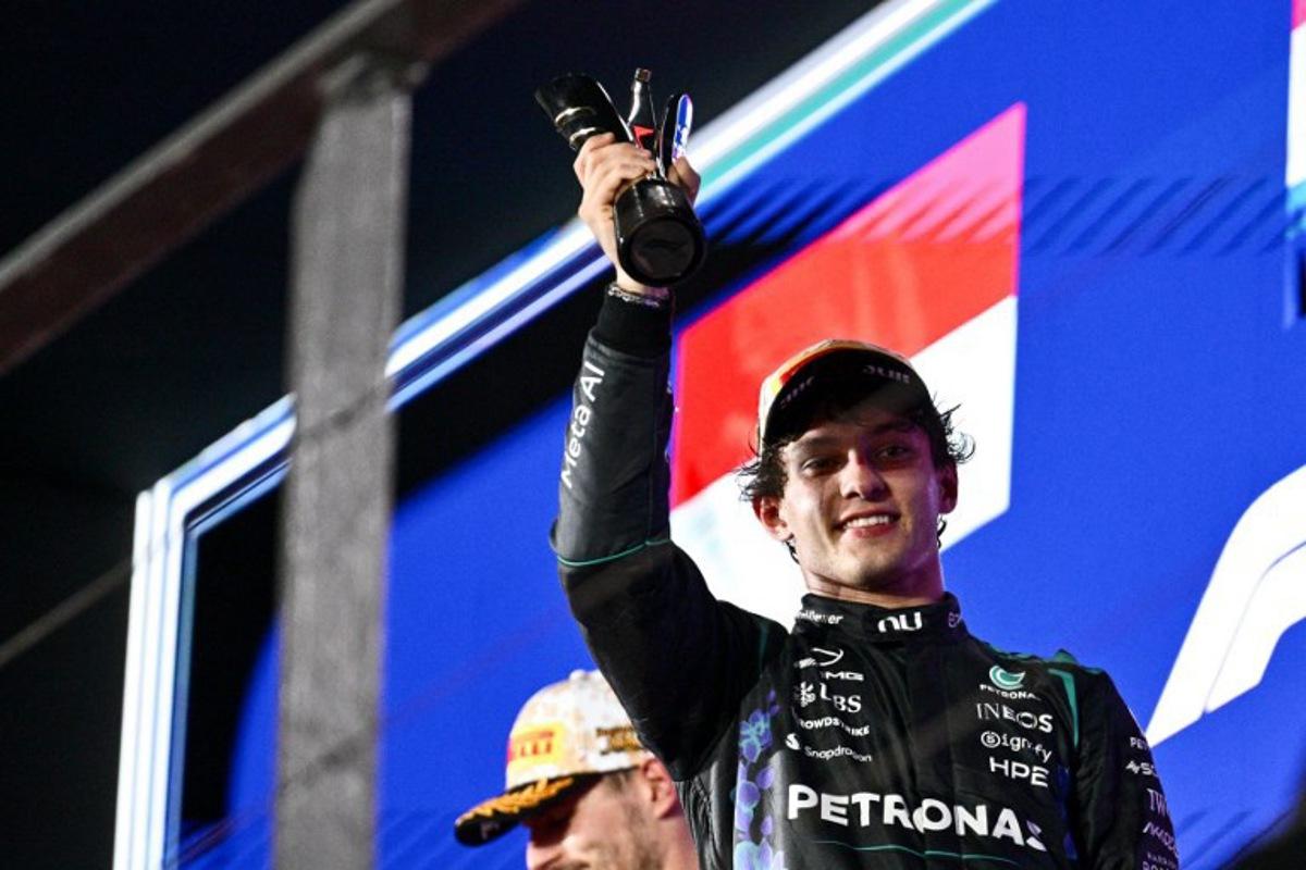 Third-placed Mercedes' Italian driver Kimi Antonelli lifts his trophy as he celebrates on the podium after the Formula One Singapore Grand Prix at the Marina Bay Street Circuit in Singapore on October 11, 2026.  ANTHONY WALLACE / AFP