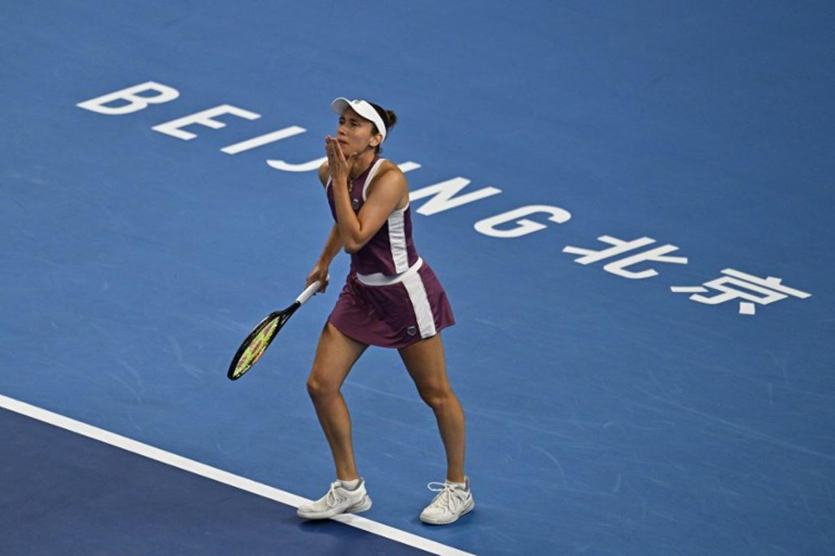 Belgium's Elise Mertens reacts after winning her women's singles quarter-final match against Poland's Iga Swiatek at the China Open tennis tournament in Beijing on October 9, 2026.  Pedro Pardo / AFP