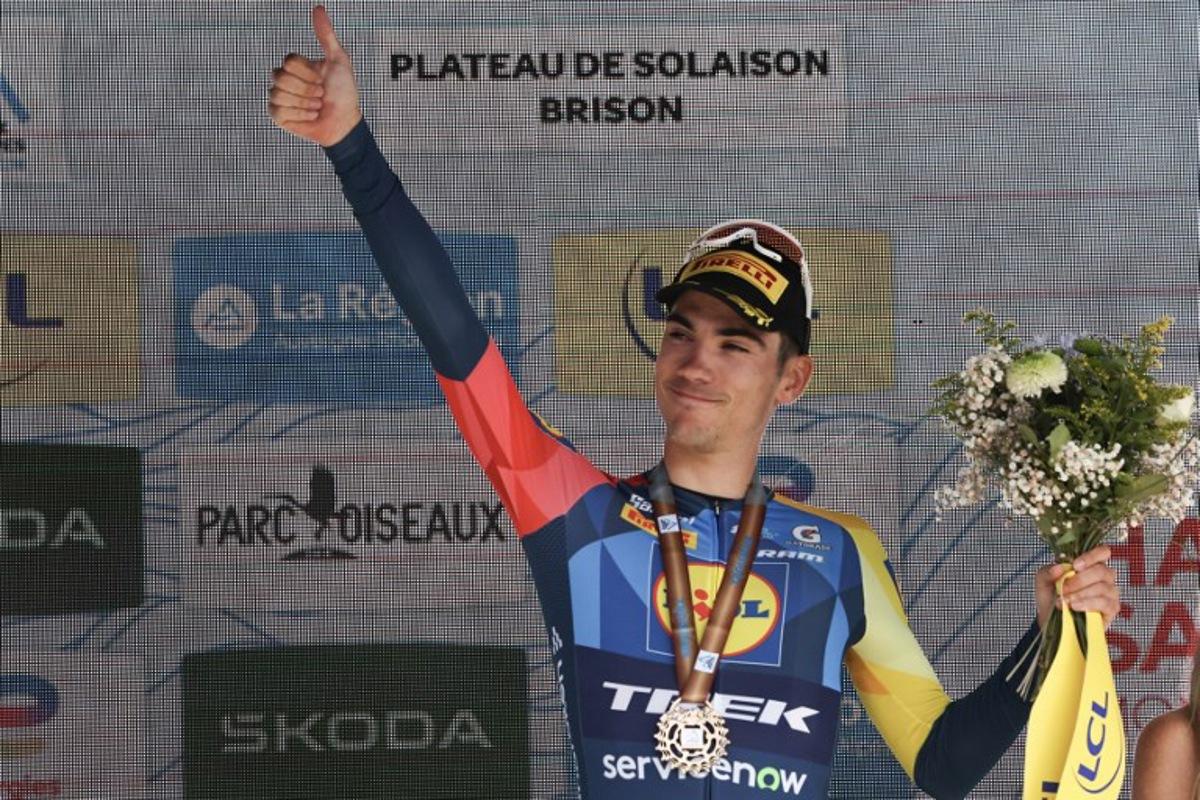 Third-placed Lidl-Trek's Spanish rider Juan Ayuso celebrates on the podium after the 8th and final stage of the Tour Auvergne-Rhone-Alpes cycling race (formerly known as the Criterium du Dauphine), 120,1km between Beaufort and Plateau de Solaison, in the French Alps on June 14, 2026.  Anne-Christine POUJOULAT / AFP