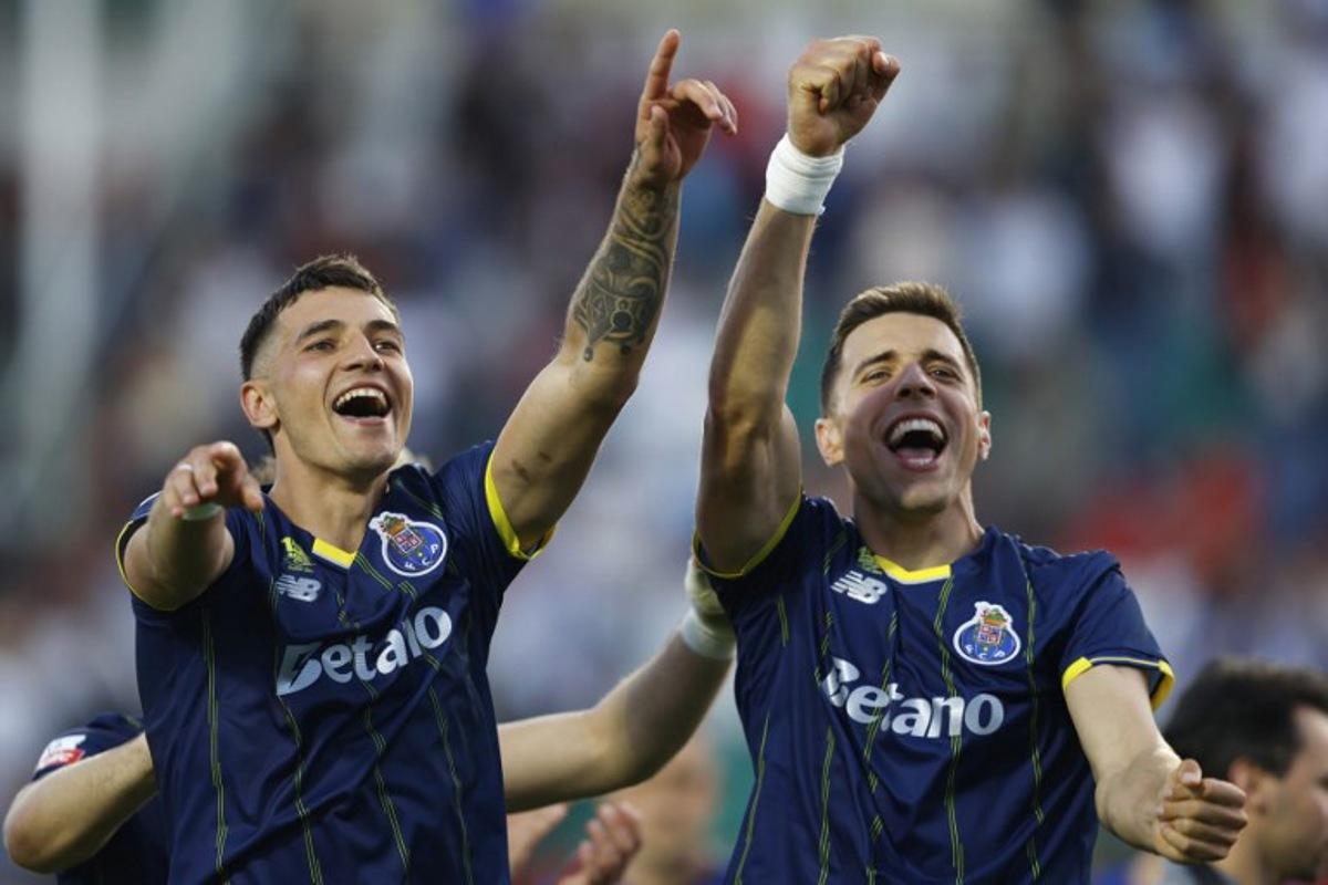 FC Porto's Polish defender #04 Jakub Kiwior (L) and FC Porto's Polish defender #05 Jan Bednarek celebrate at the end of the Portuguese League football match between CF Estrela da Amadora and FC Porto at Jose Gomes stadium in Amadora, on April 26, 2026.  FILIPE AMORIM / AFP