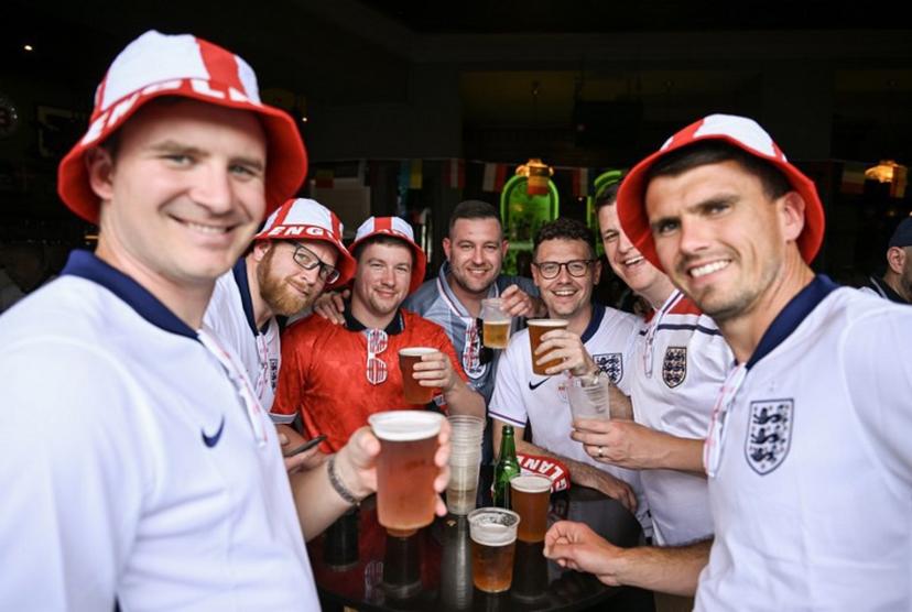 England supporters pose with beer glasses in the area of the main station of Frankfurt am Main on June 20, 2024, before the UEFA Euro 2024 Group C football match between Denmark and England.  Kirill KUDRYAVTSEV / AFP