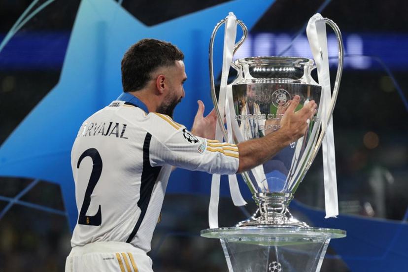 Real Madrid's Spanish defender #02 Dani Carvajal touches the trophy as he celebrates after winning the UEFA Champions League final football match between Borussia Dortmund and Real Madrid, at Wembley stadium, in London, on June 1, 2024. Real Madrid wins the Champions League final 2 - 0 against Borussia Dortmund. Adrian DENNIS / AFP