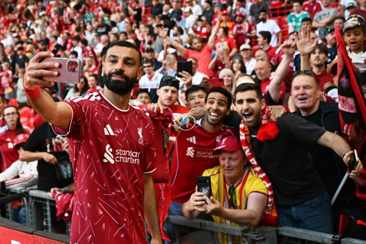 Liverpool's Egyptian striker #11 Mohamed Salah takes a selfie with fans after the English Premier League football match between Liverpool and Brentford at Anfield in Liverpool, north west England on May 24, 2026.  Paul ELLIS / AFP