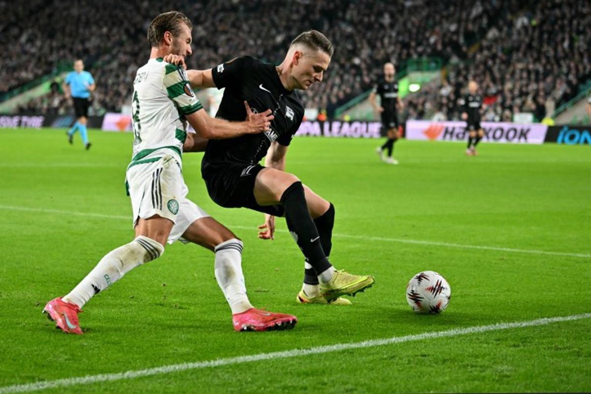 Celtic's Swedish midfielder #08 Benjamin Nygren battles for the ball with Sturm Graz's Belgian defender #24 Dimitri Lavalee during the UEFA Europa League league-stage football match between Celtic and Sturm Graz at Celtic Park in Glasgow on October 23, 2025.  ANDY BUCHANAN / AFP