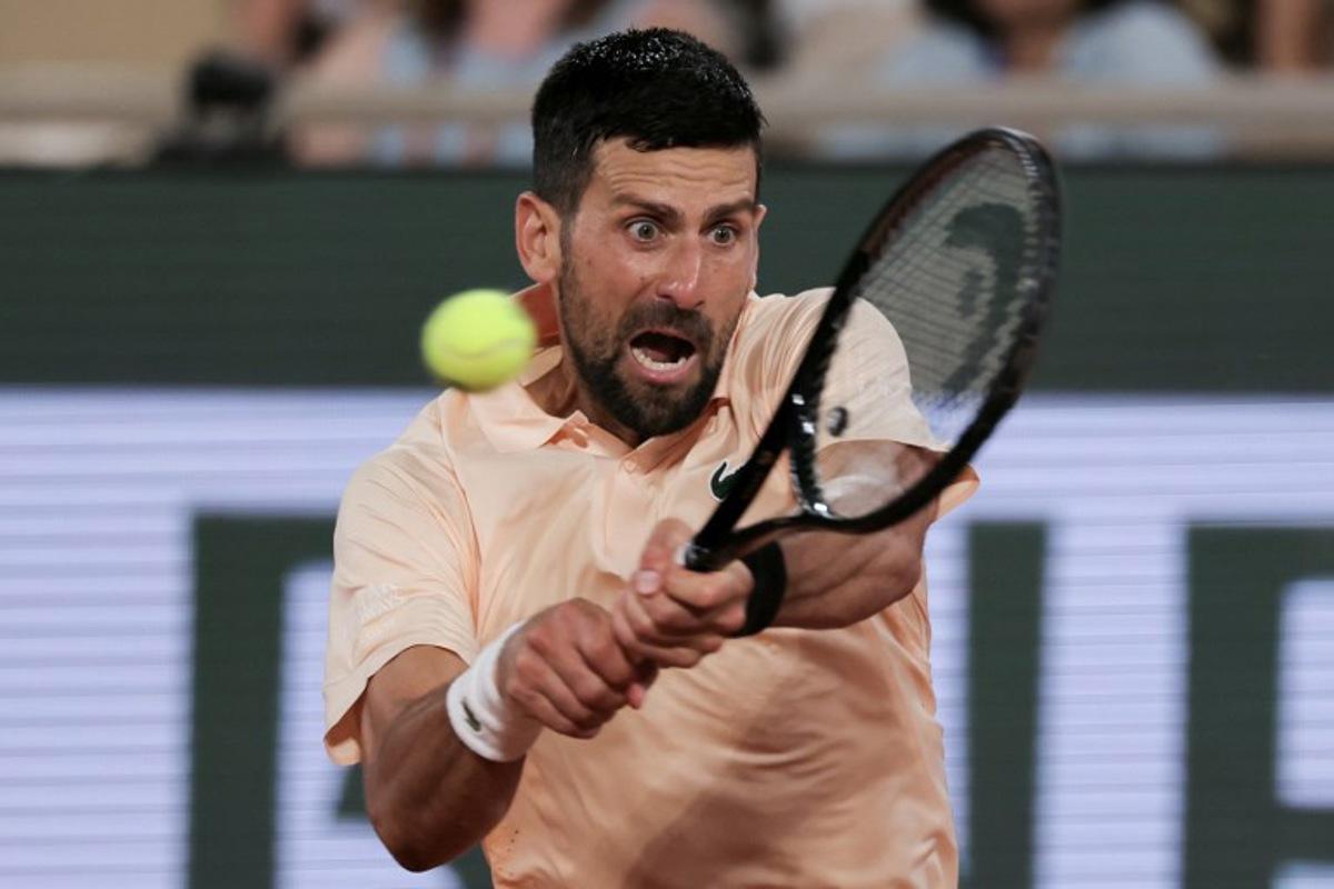 Serbia's Novak Djokovic plays a backhand return to France's Giovanni Mpetshi Perricard during their men's singles match on day 1 of the French Open tennis tournament on Court Philippe-Chatrier at the Roland-Garros Complex in Paris on May 24, 2026.  Thomas SAMSON / AFP